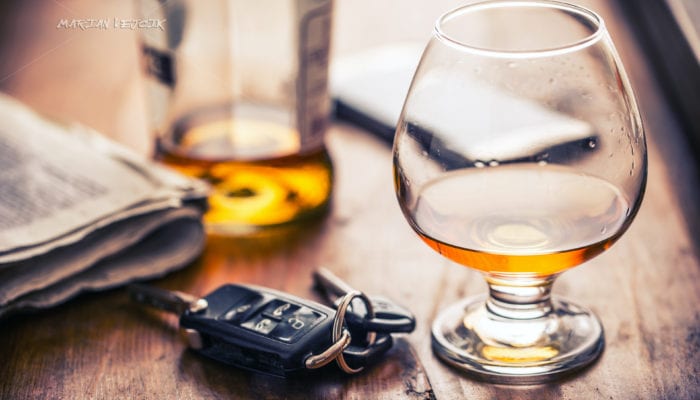 photo of car keys resting on a table next to a snifter of alcohol. DUI Lawyer